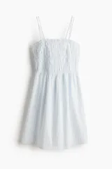Vestido corto de algodón a rayas celestes y blancas, con cuerpo fruncido, escote cuadrado y breteles spaghetti dobles.