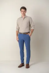 Pantalón de vestir azul con corte slim fit y cinturón de cuero trenzado.