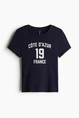 Remera azul marino de algodón con cuello redondo y estampado frontal blanco con la frase "Côte D'Azur", el número 19 y la palabra "France".