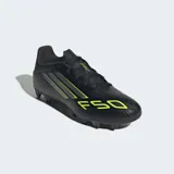 Championes de fútbol Adidas F50 Club para múltiples superficies, color negro con detalles en amarillo neón. Presentan un diseño con franjas diagonales y el número "F50" estampado en la puntera.