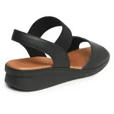 Sandalia casual de cuero color negro con suela color caramelo. Cuenta con una tira ancha de cuero con perforaciones en la parte delantera y una tira elástica en el tobillo para mayor ajuste.