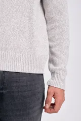 Sweater de tejido de punto color gris claro jaspeado, con cuello redondo y manga larga.