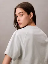 Remera verde agua de algodón, corte cropped y calce holgado. Tiene cuello redondo y logo de la marca bordado en el frente.