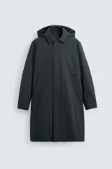 Parka larga color verde oscuro, con capucha desmontable, cuello solapa, bolsillos laterales y cierre frontal con cremallera oculta y botones a presión. Incluye chaleco interior acolchado desmontable.