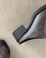 Zuecos marrones de cuero sintético con suela y taco cuadrado negros.