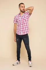 Camisa de manga corta con estampado a cuadros en tonos azul, rojo y blanco. Cierre con botones y tela ligera.