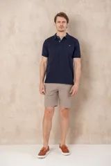 Chomba azul con cuello clásico, tapeta de dos botones y logo bordado en el pecho.