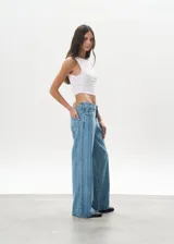 Pantalón de jean celeste con rayas verticales, tiro bajo y corte wide leg.