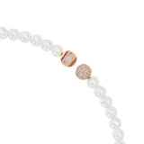 Collar de perlas de cristal blancas con cierre magnético y dos dijes en forma de pluma bañadas en tono oro rosa, con pavé rosa y una Swarovski Zirconia.