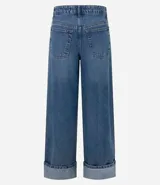 Pantalón de jean azul, de corte ancho, con bolsillos delanteros y traseros, y ruedo con dobladillo.