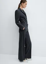 Americana entallada color gris oscuro, con solapas de muesca, manga larga con puños abotonados, bolsillo de ribete en el pecho, forro interior y cierre frontal con botones. Diseño body.