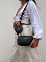 Bandolera compacta de símil cuero color mostaza, con correa de tela regulable y monedero redondo desmontable.