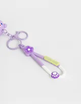 Llavero con dije de osito lila con un patito de goma en su capucha y llavero con dije de flor lila y strap de silicona con la inscripción "Luck Day".