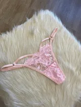 Tanga de encaje floral color rosa, con tiras finas regulables.