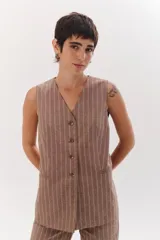 Chaleco gris con finas rayas verticales blancas, con cuello en V, cierre frontal con botones y bolsillos laterales.