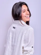 Vestido camisero largo de lino color beige, con cuello clásico, manga larga con puños abotonados y cierre frontal con botones. Tiene un bolsillo de parche en el pecho.