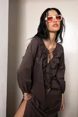 Vestido largo color marrón con tajos laterales, escote con volados y lazos con punteras metálicas.