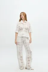 Pantalón cargo de tiro medio color blanco, confeccionado en crochet y lino broderie.