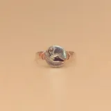 Anillo ovalado con diseño de mano sosteniendo una flor, en plata 925 con detalles en oro 9k. Hecho a medida.