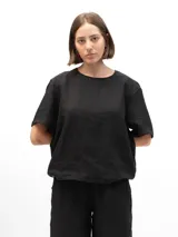 Remera negra de lino con mangas cortas y corte holgado. Tiene botones en la espalda.