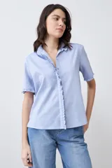 Camisa celeste de manga corta con cuello y ruedo con volados.