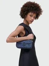 Bolso bandolera Marc Jacobs modelo The Puffy Daisy Denim Clover, confeccionado en denim azul con estampado de flores y logo de la marca en el cierre.