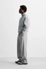 Pantalón jogger gris de corte recto, confeccionado en tejido de algodón compacto con interior en rizo. Cuenta con cintura elástica ajustable con cordón interior, bolsillos frontales y bolsillo de doble vivo en la espalda.