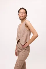 Chaleco marrón con escote en V y cierre cruzado con dos botones.