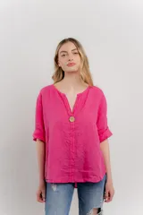 Blusa celeste de lino, con escote en V, manga tres cuartos y botón de madera.
