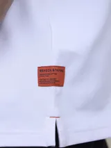 Polo de piqué azul marino, de corte clásico, con cuello abotonado y mangas cortas.