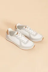 Zapatillas deportivas blancas con detalles en gris y marrón claro.