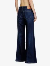 Pantalón de jean acampanado de tiro bajo, color azul oscuro, con bolsillos delanteros y traseros.