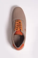 Zapatillas casuales color beige con cordones y suela de goma blanca.