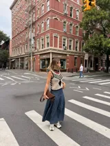 Falda larga de tela de jean con diseño de caderín y tablas.