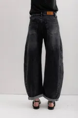 Pantalón de jean negro con corte amplio y ruedo doblado.