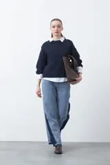 Jean de calce ultra wide confeccionado en denim de algodón color negro. Presenta una silueta amplia desde la cadera y un panel lateral en contraste que estiliza la pierna.