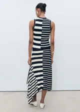 Falda midi de punto con estampado de rayas horizontales en blanco y negro. Presenta cintura elástica, corte evasé y bajo asimétrico.