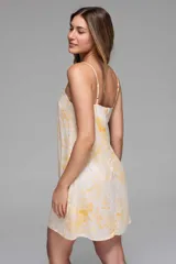 Vestido corto de tirantes finos, con estampado zodiacal en tonos amarillo, marrón y azul sobre fondo blanco.