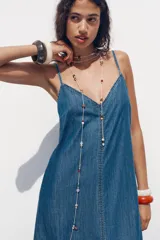 Vestido midi de denim azul, con escote en pico y tirantes finos.