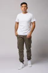 Pantalón cargo color beige de gabardina, con corte ajustado, bolsillos laterales con fuelle y puños elásticos en los tobillos.
