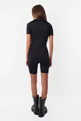 Mono corto negro de microfibra con calce slim, cuello polo, escote en V pronunciado, cierre frontal y mangas cortas.