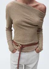Camiseta color beige con textura, cuello asimétrico y manga larga. Diseño entallado.