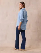 Blusa celeste de lyocell, con cuello con solapa, escote en V y abertura con botones. Mangas ¾ con puño y botón.