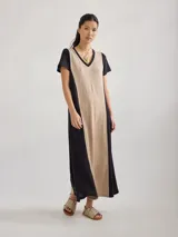 Vestido largo de tejido de punto color beige con paneles laterales negros y escote en V.