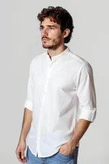 Camisa blanca de cuello mao y mangas 3/4 con botón para sujetar.