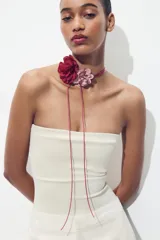 Collar con cordón fino color fucsia y apliques de dos flores de tela, una color borgoña y otra rosa pálido.