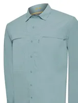 Camisa de manga larga color celeste, con cuello clásico, cierre frontal con botones, dos bolsillos frontales con solapa y ventilación en sisas y canesú.