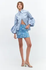 Minifalda de jean celeste con estampado de flores blancas.