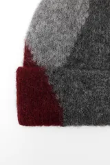 Gorro tipo beanie tejido con alpaca, con diseño de bloques de color en gris, azul y azul marino.