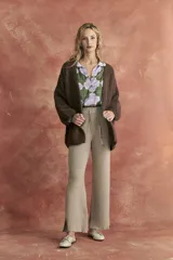 Pantalón de tejido color beige, de corte recto y tiro alto, con cintura elastizada y cordón ajustable.